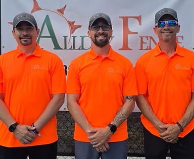Victor, Marcelo, and Roger — the three brothers behind Allday Fence — standing in front of the company banner